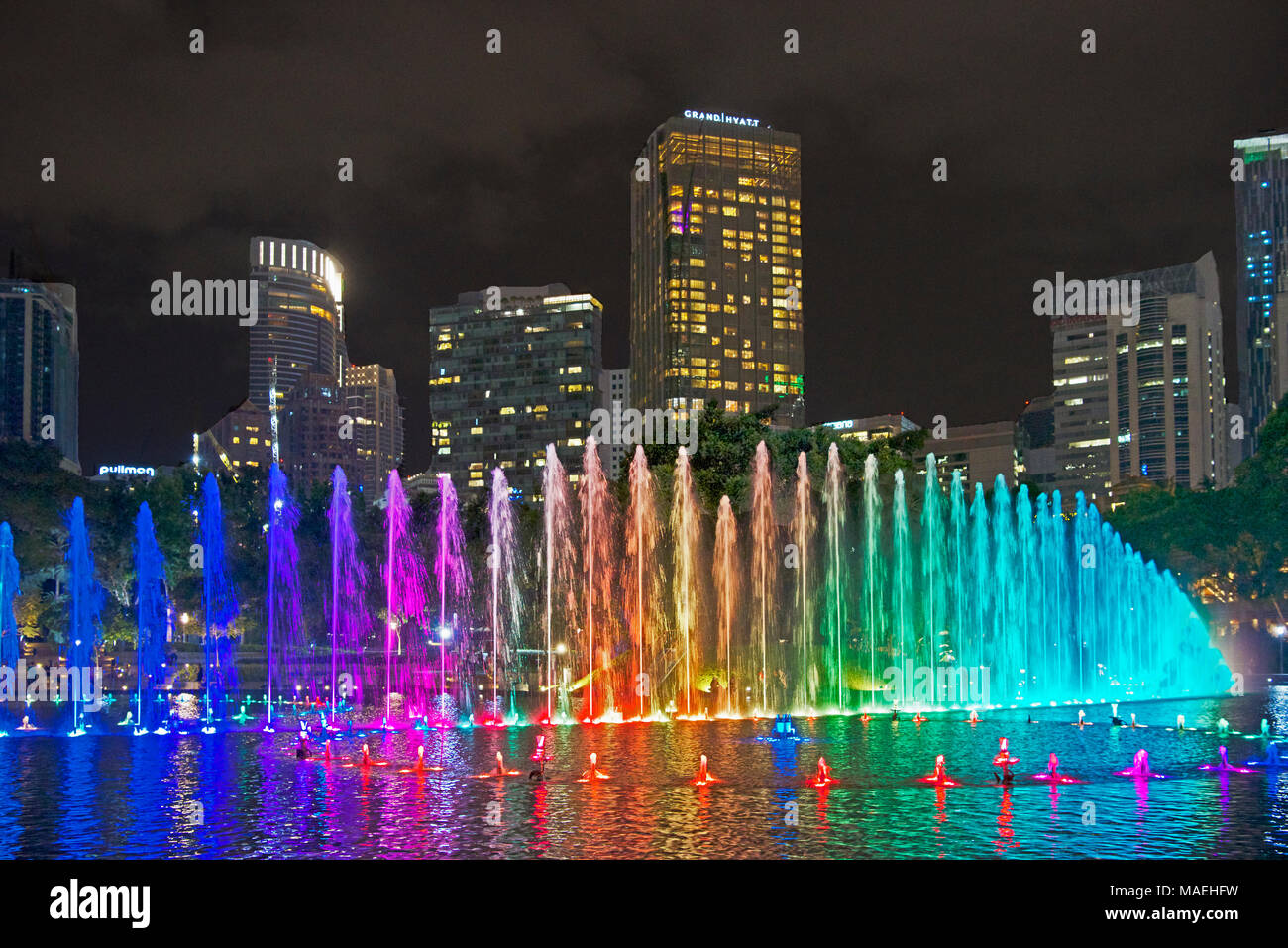 Multi coloured fountains and city skyscrapers at night Kuala Lumpur Malaysia Stock Photo