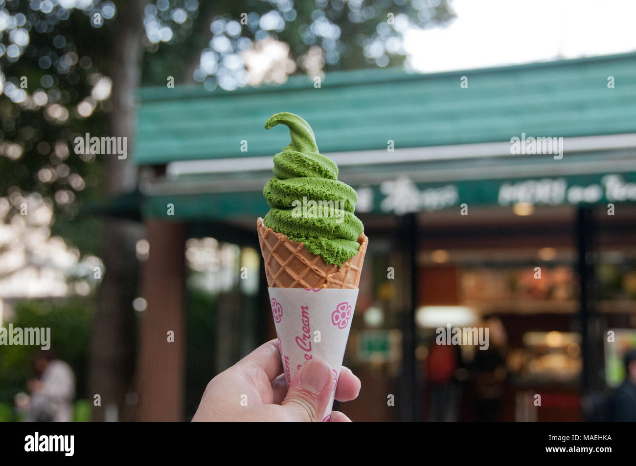 Left hand holding Green tea matcha flavour soft serve ice cream in Tokyo Stock Photo