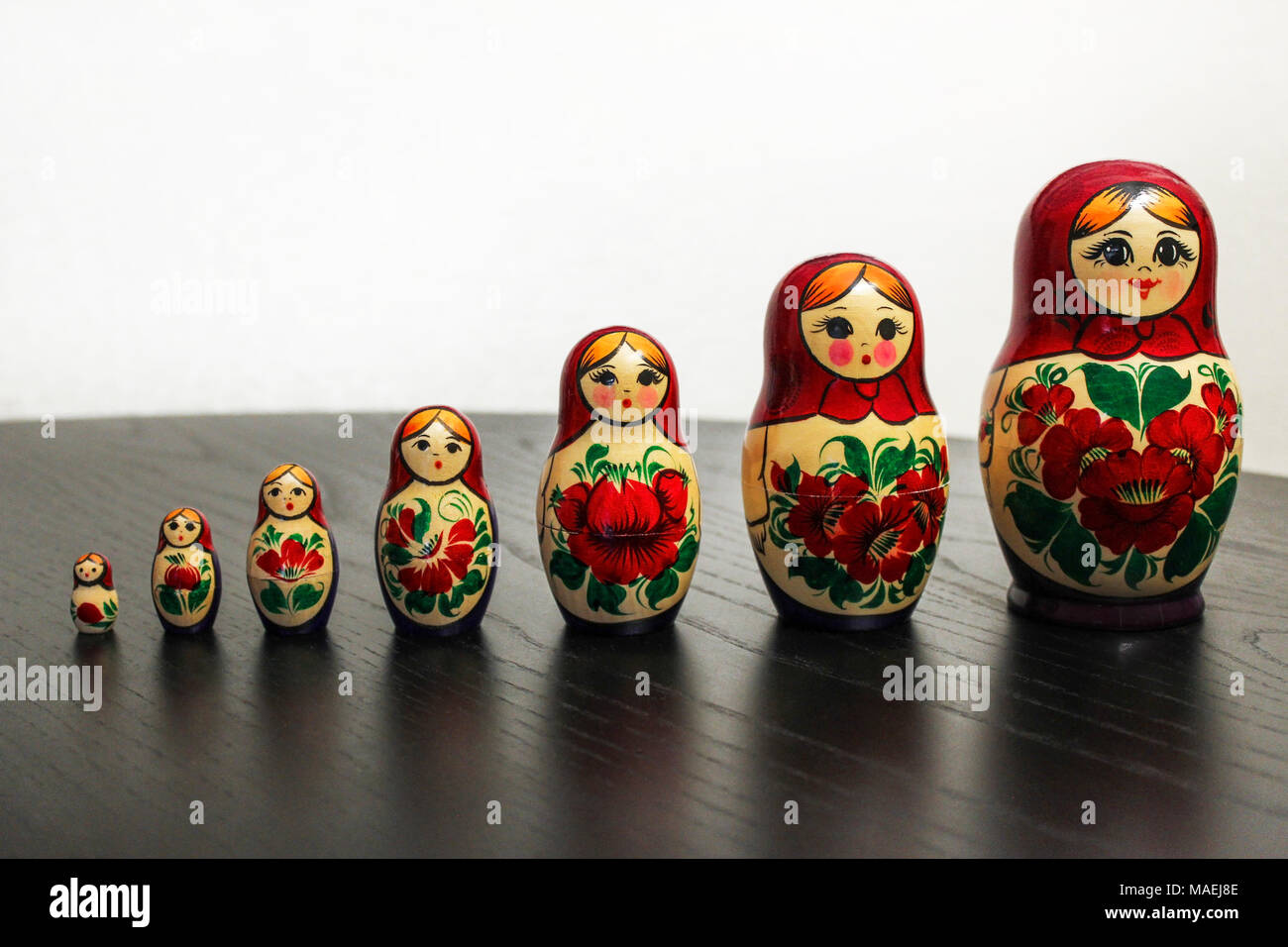 Russian nesting dolls in a row on a black wooden table Stock Photo
