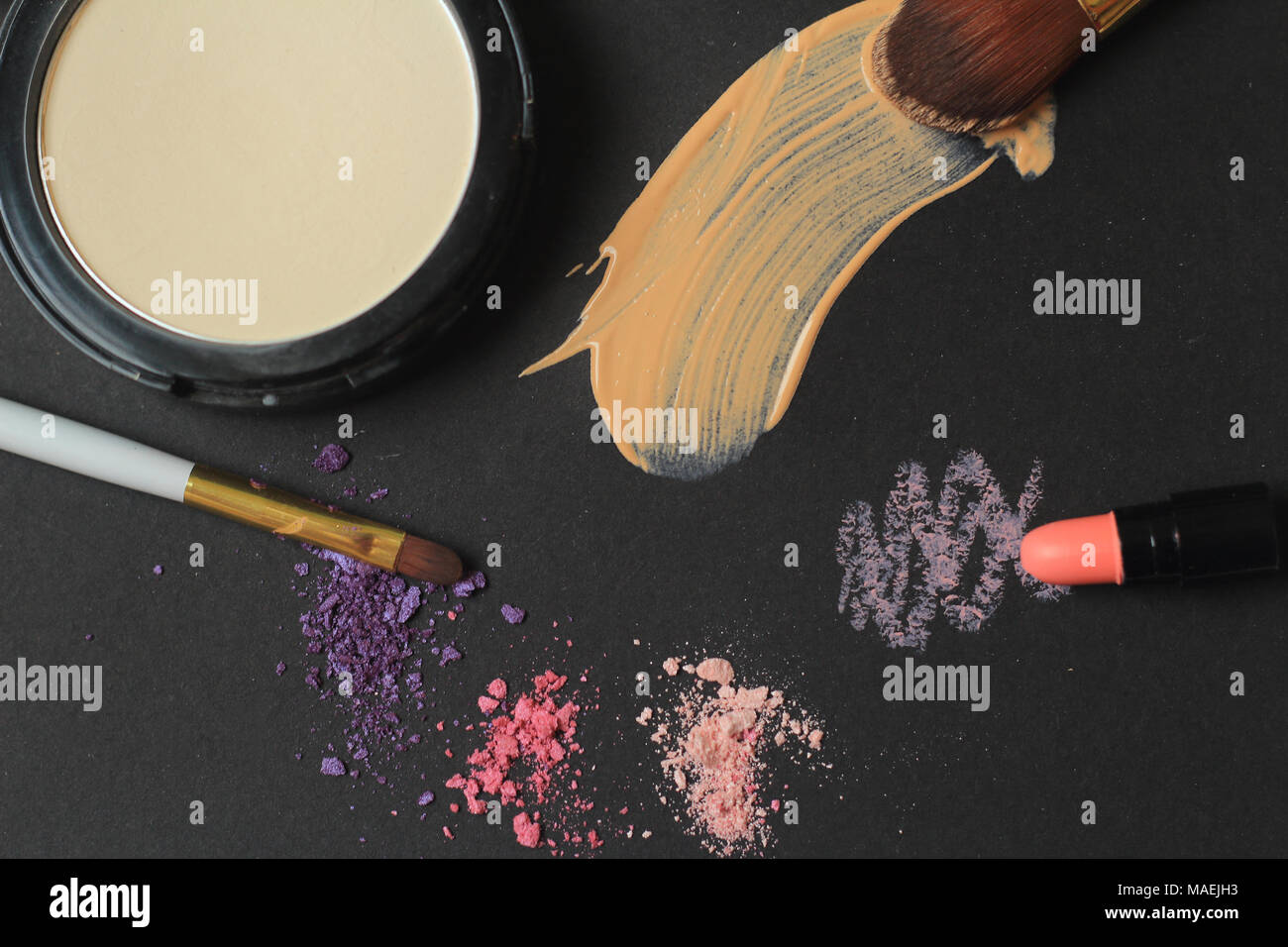 close up. makeup brushes, powder and cream strokes on black background. Stock Photo