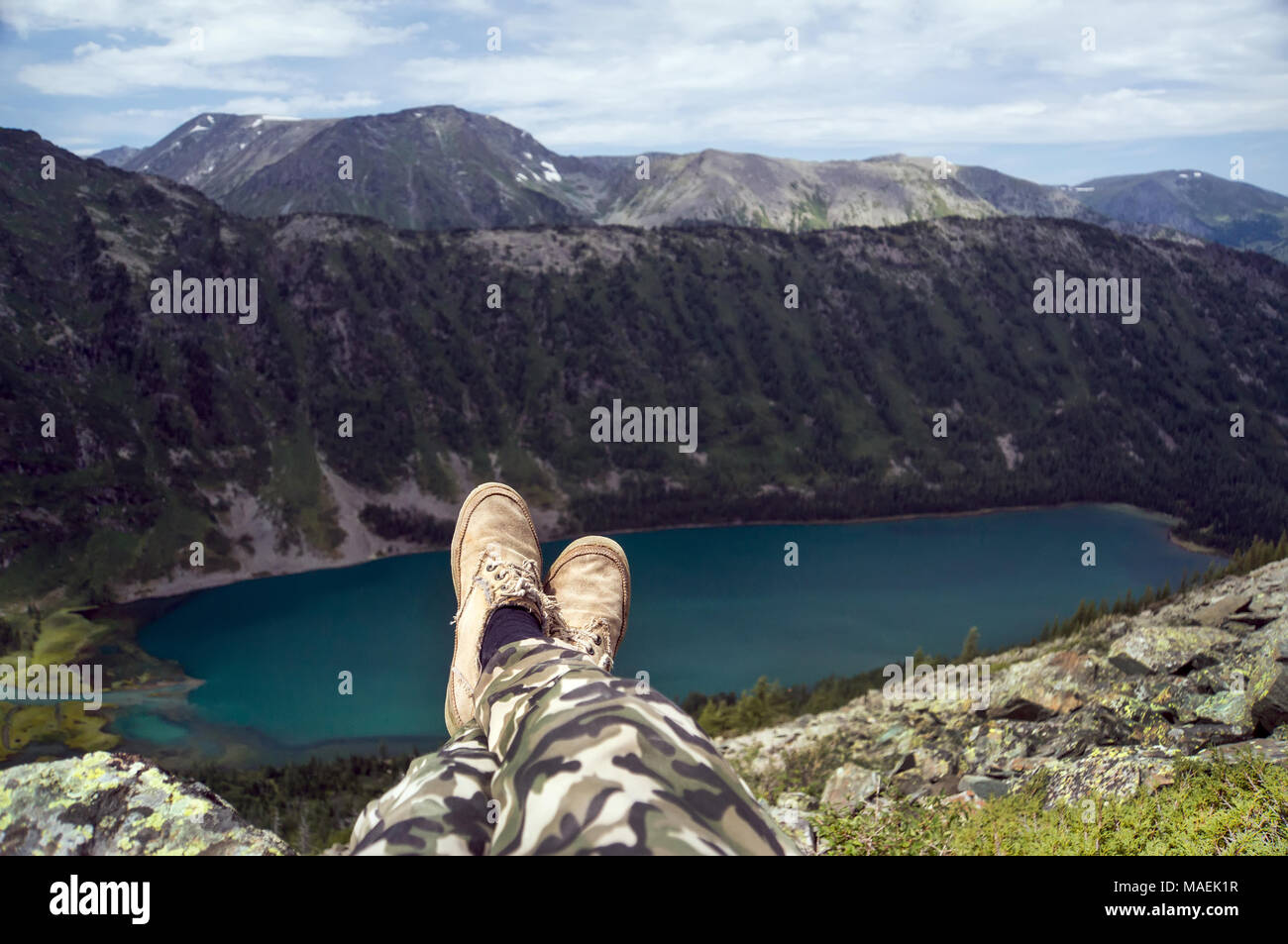 Legs and hiking shoes of a traveler sitting Stock Photo
