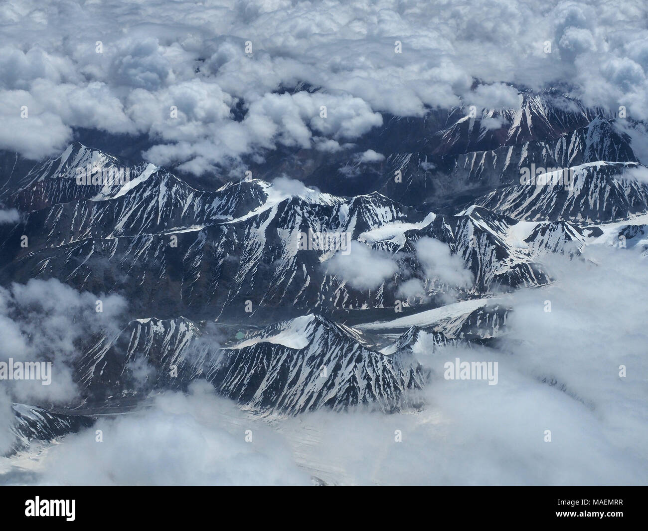 High chains are mountain ranges with snowy peaks amidst cumulus clouds ...