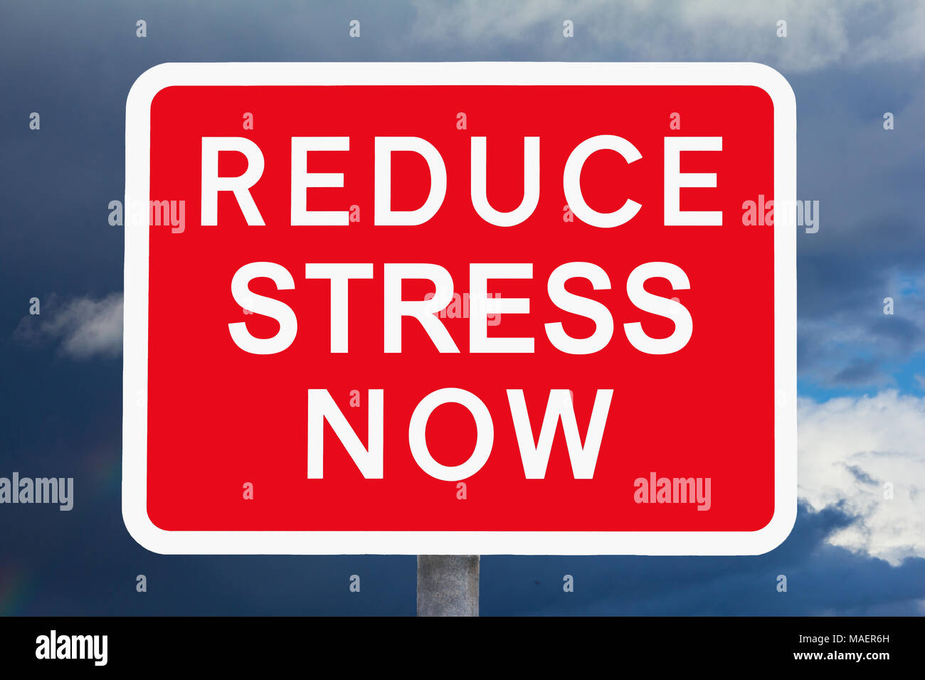 Red and white warning sign REDUCE STRESS NOW in front of a dark sky, symbol for health risk, variation of a british traffic sign Stock Photo