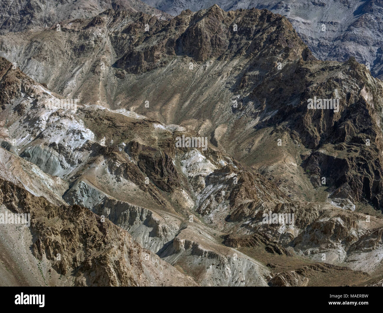 Fragment of a natural mountain slope: ridges of dark rocks alternate ...