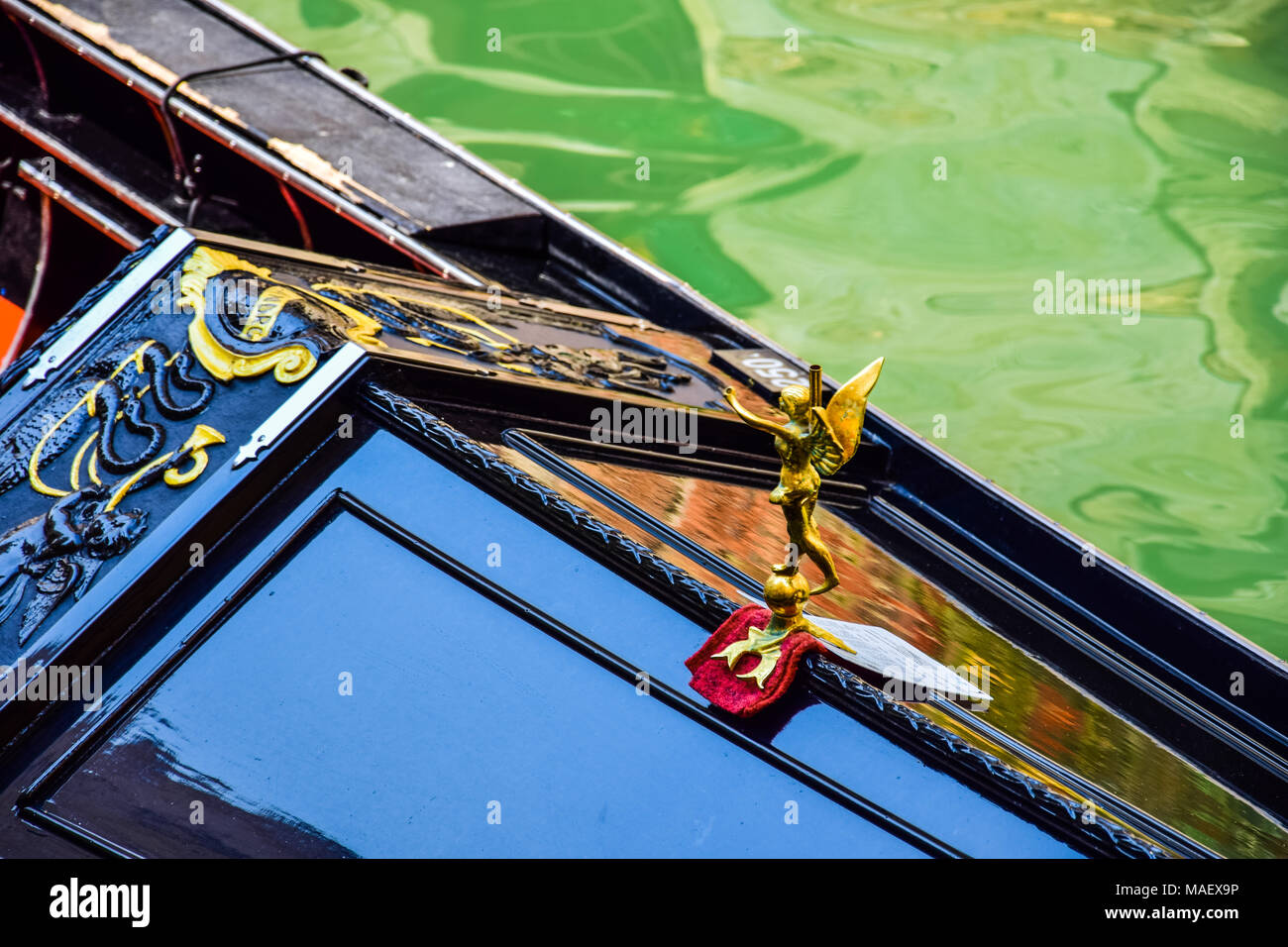 Detail showing a gold, winged figure decorating a gondola in Venice in Italy Stock Photo