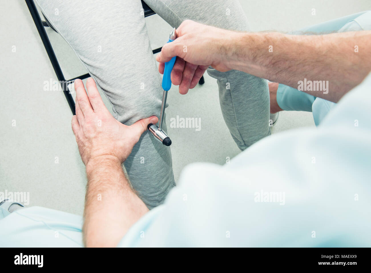 The neurologist testing knee reflex on a female patient using a hammer. Neurological physical examination. Selective focus, close up Stock Photo
