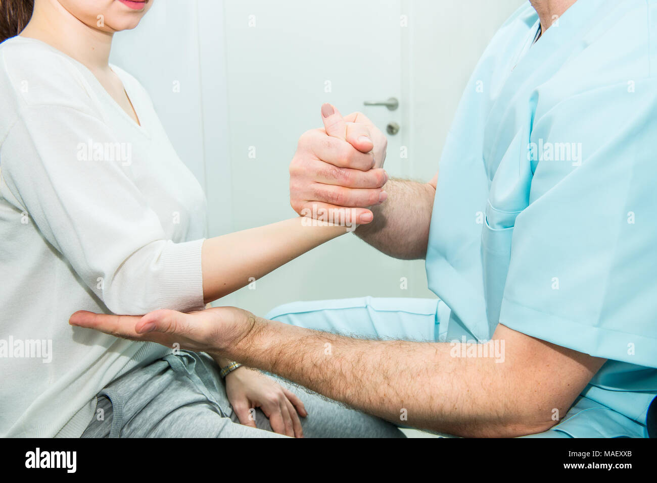 Neurological physical examination of the hands reflexes. Doctor neurologist checks the status of the patient's reflexes in office in hospital. Selecti Stock Photo