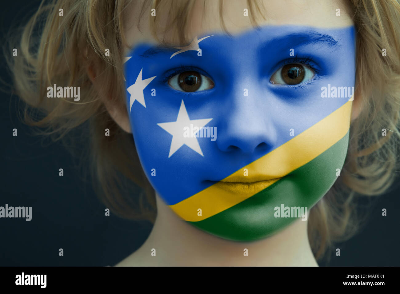Child with a painted flag of Solomon Islands Stock Photo