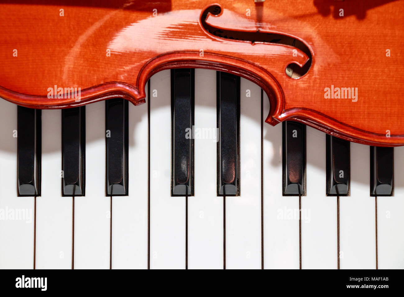 violin on the piano black and white keys closeup look Stock Photo - Alamy
