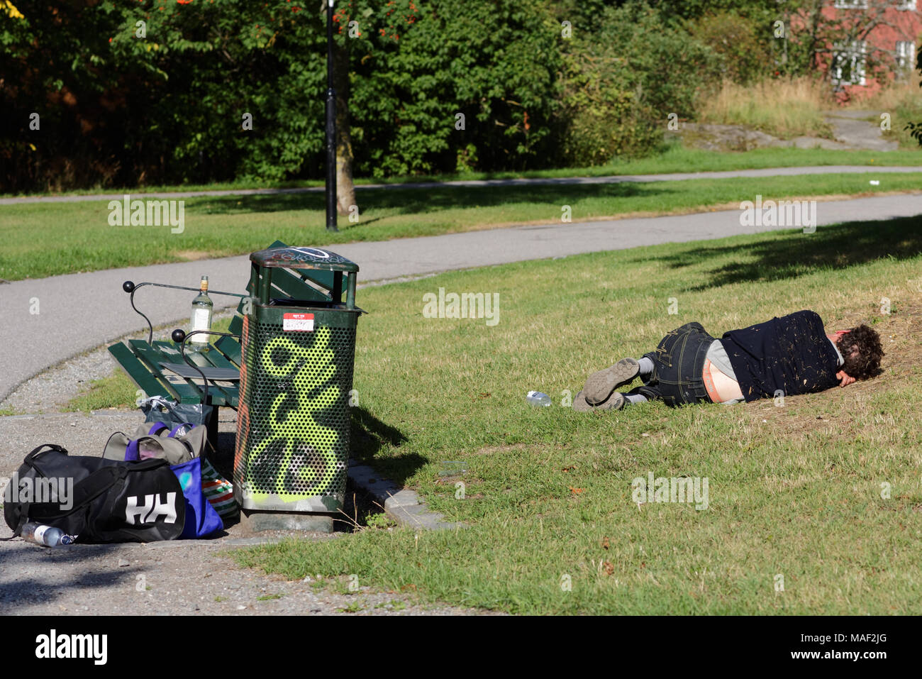 Man sleeping on a grass in a public park in Stockholm, Sweden Stock Photo