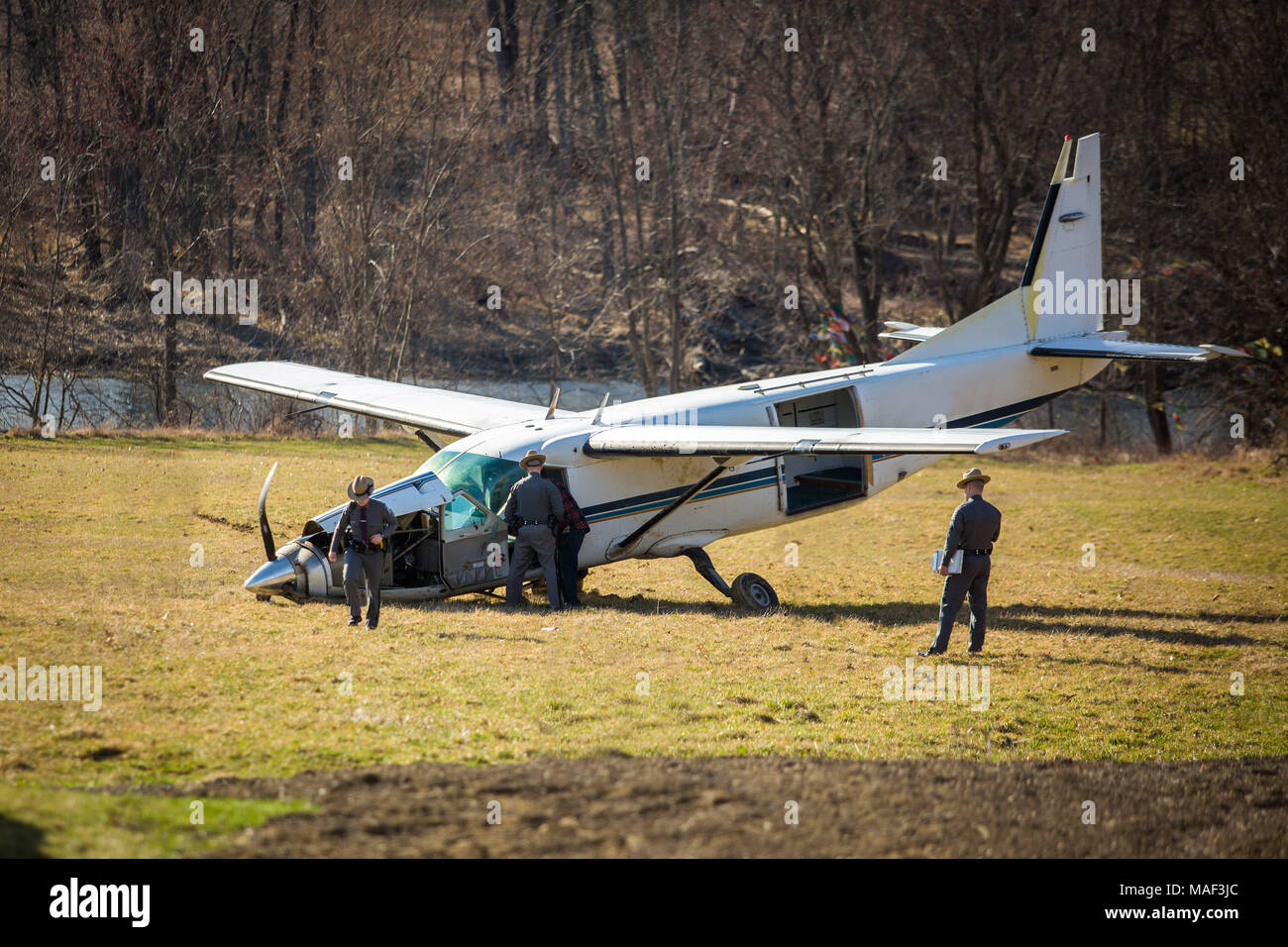 Crashed broke plane on field with police investigating Stock Photo