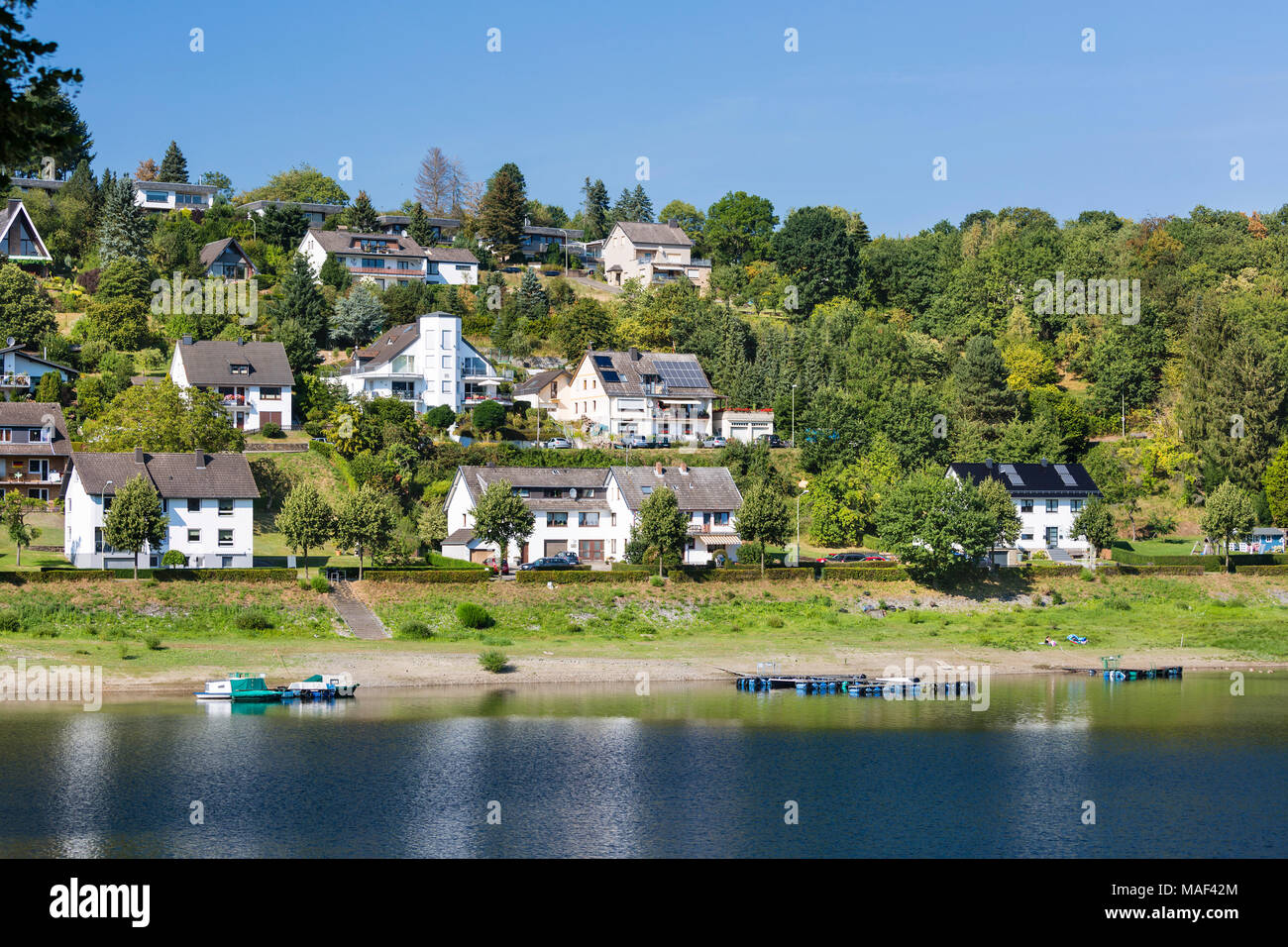 Houses at the beach in Rurberg at Lake Rursee with perfect blue sky in