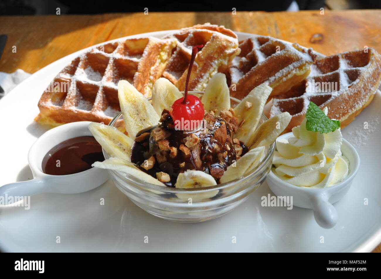 https://c8.alamy.com/comp/MAF52M/waffles-with-ice-cream-sundae-whipped-cream-and-chocolate-sauce-MAF52M.jpg