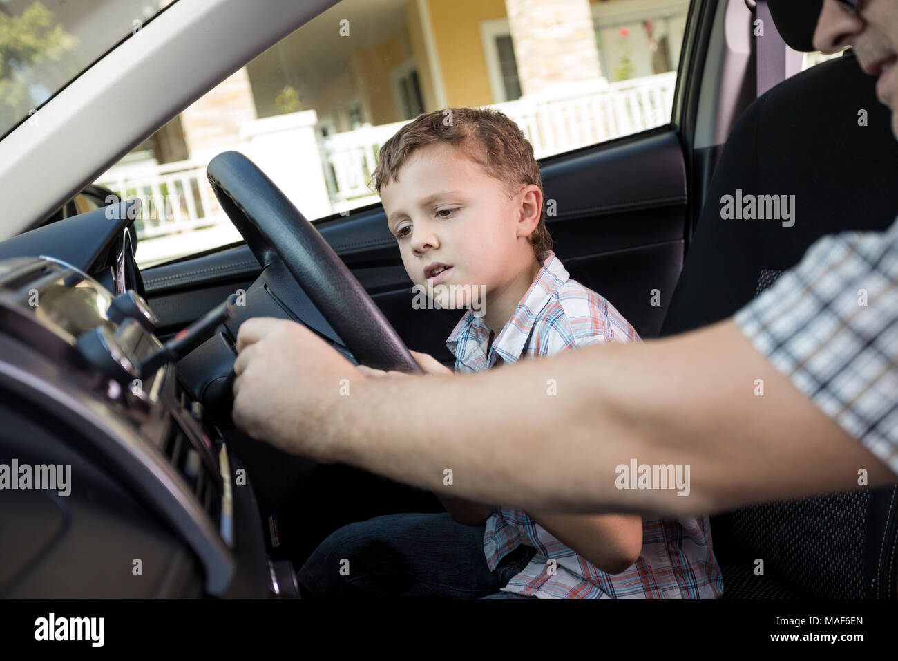 Happy father and son sitting in the car at the day time. People getting ready for road trip. Concept of happy family. Stock Photo