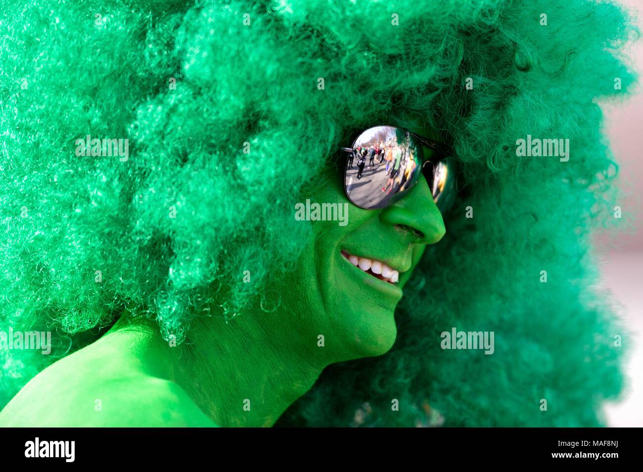 Chicago, Illinois, USA. Fitted in green from head to toe, befitting the theme of the race, a runner pauses beyond the finish line. Stock Photo