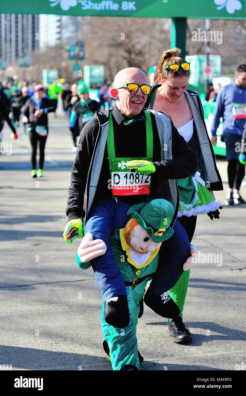Chicago, Illinois, USA. Outfitted as man riding the back of a leprechaun, befitting the theme of the race, a runner walking beyond the finish line. Stock Photo