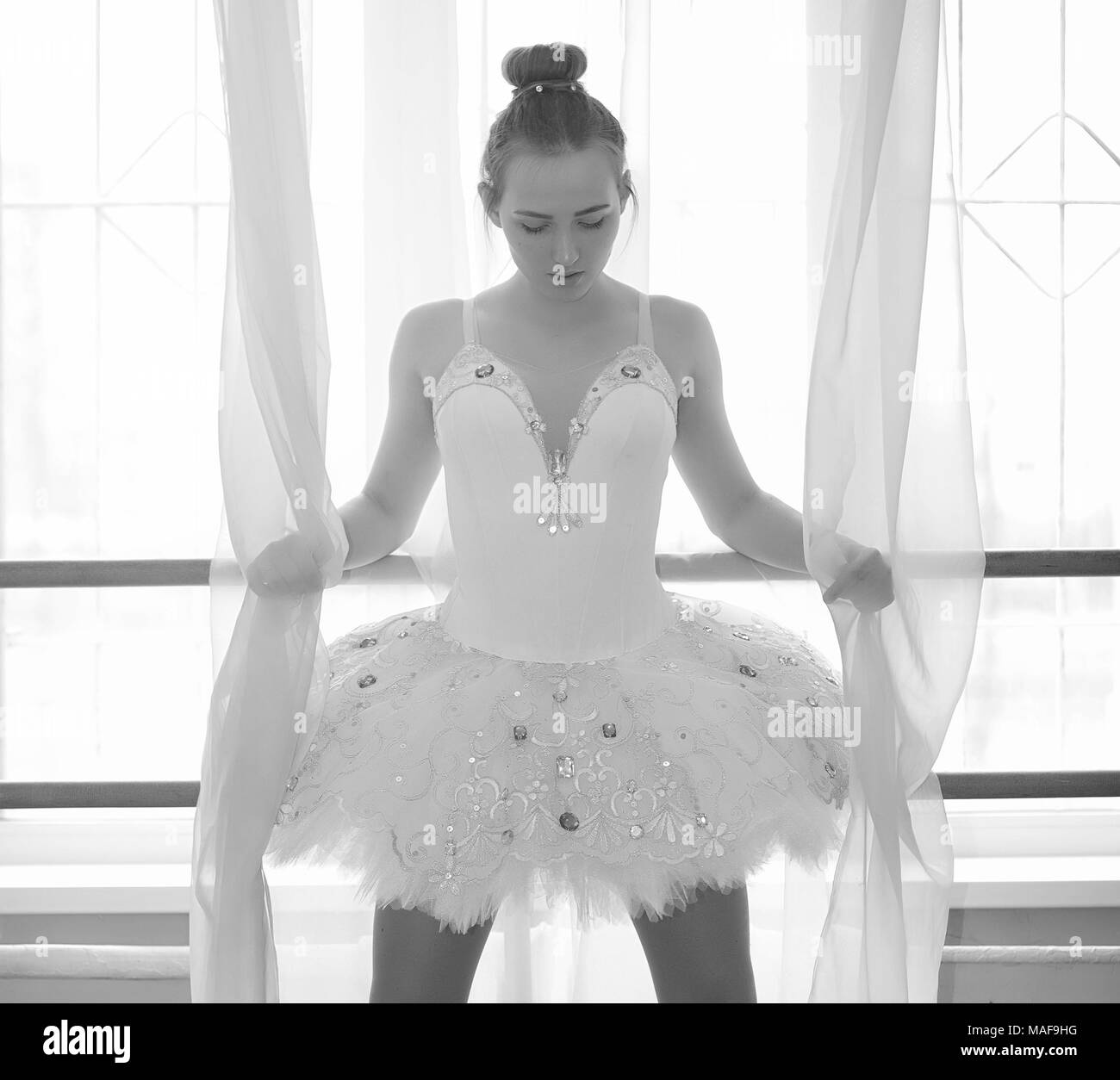 Young ballet dancer on warm-up. ballerina is preparing to perform in the studio. A girl in ballet clothes and shoes kneads by handrails Photo - Alamy