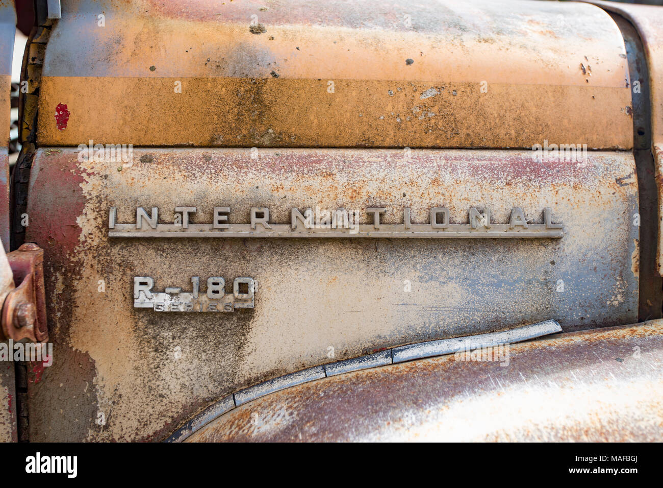 A chromed 'R-180 Series' logo above the fender on a 1954 International R-180 Series dump truck, in an old quarry, east of Clark Fork Idaho. Stock Photo