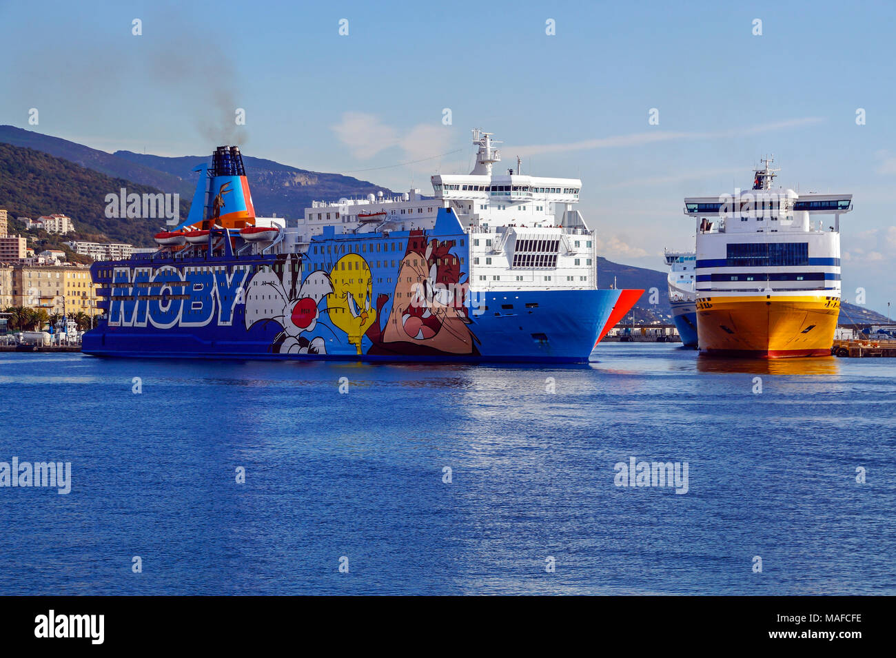 Mobi ferry Moby Dada leaving port of Bastia Corsica France Europe with Sardinia Andrea moored right Stock Photo