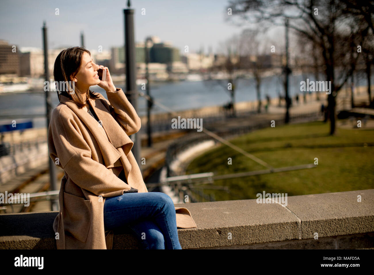 Woman talking on the mobile phone in the park Stock Photo - Alamy