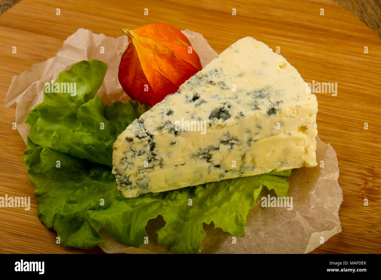 Blue cheese with salad leaves over the wooden background Stock Photo