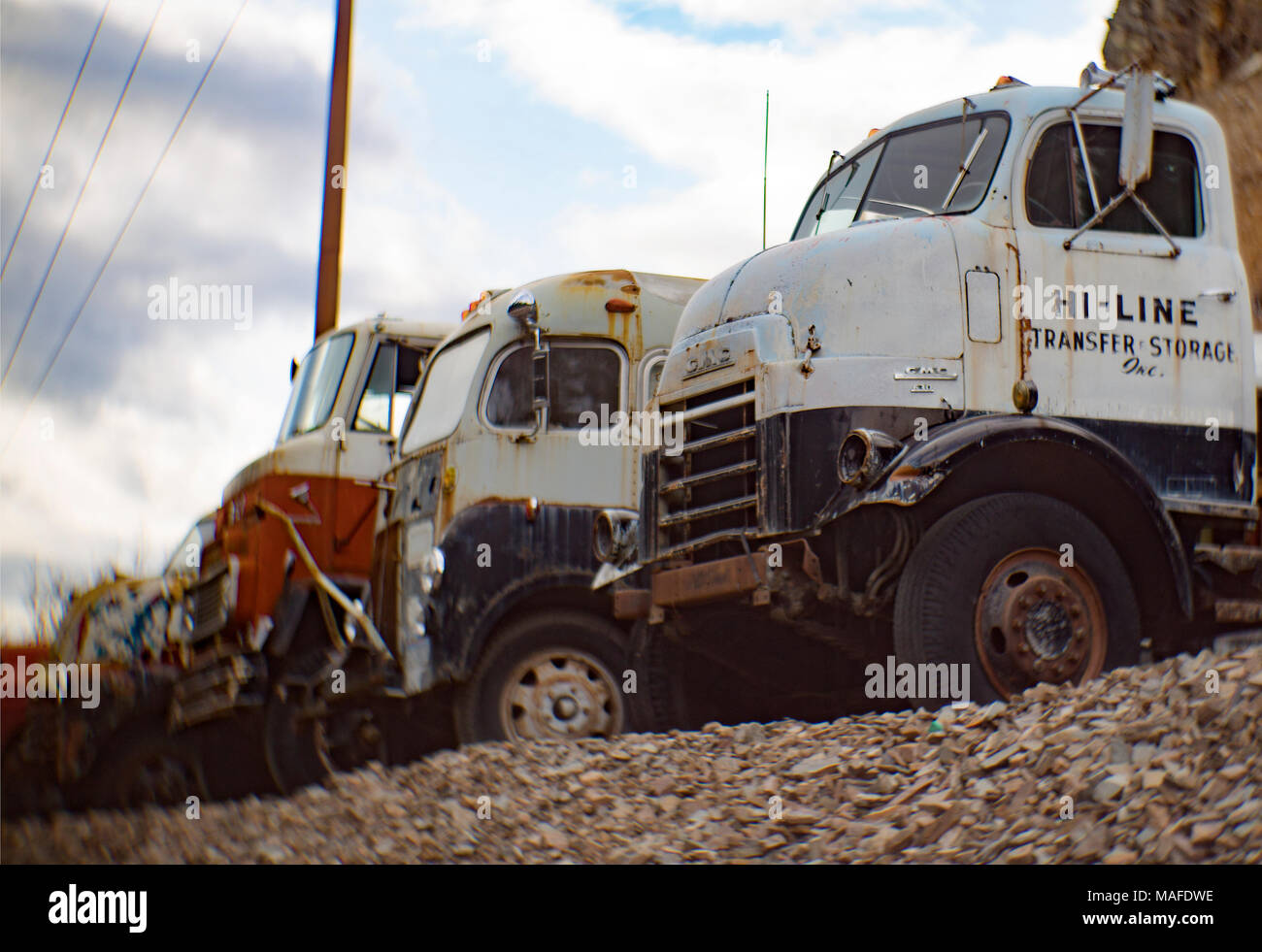 A white 1956 'Cannonball' GMC 630 cabover truck, in a row of COE trucks, located in an old stone quarry, east of Clark Fork Idaho. Stock Photo