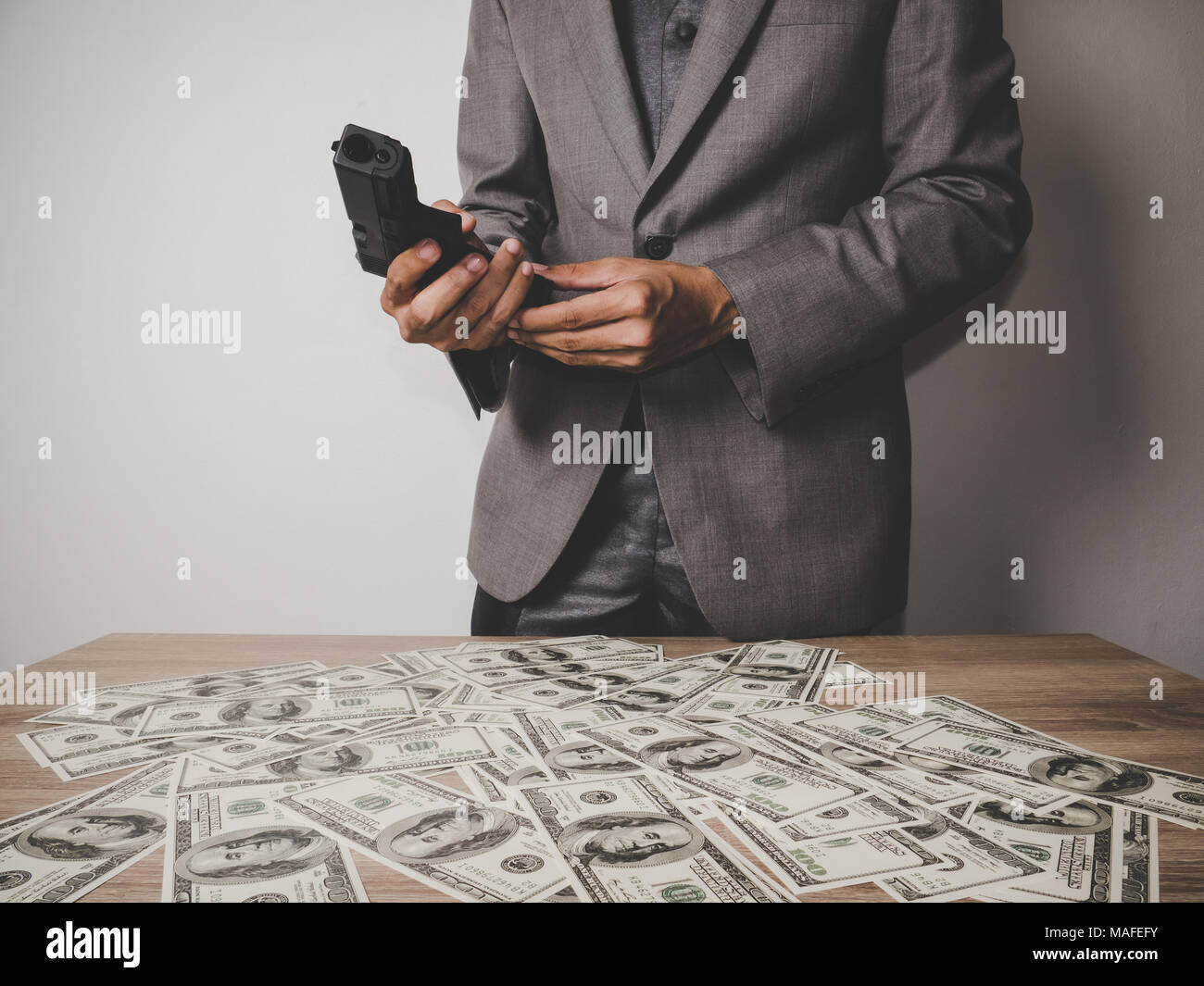Gangster man hand holding a gun with dollar banknote Stock Photo