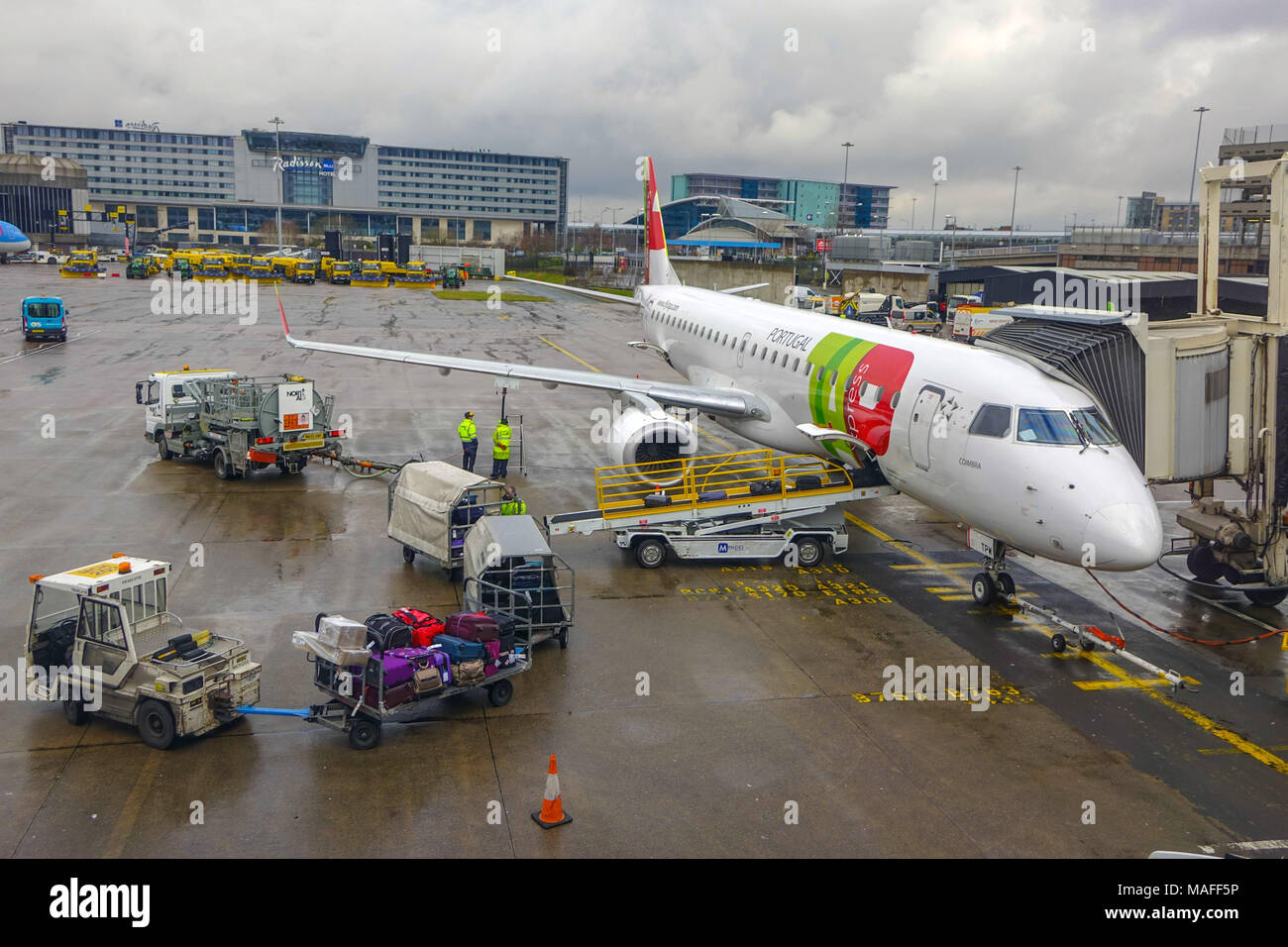Loading TAP Portugal Aircraft at Manchester airport on wet day Stock Photo