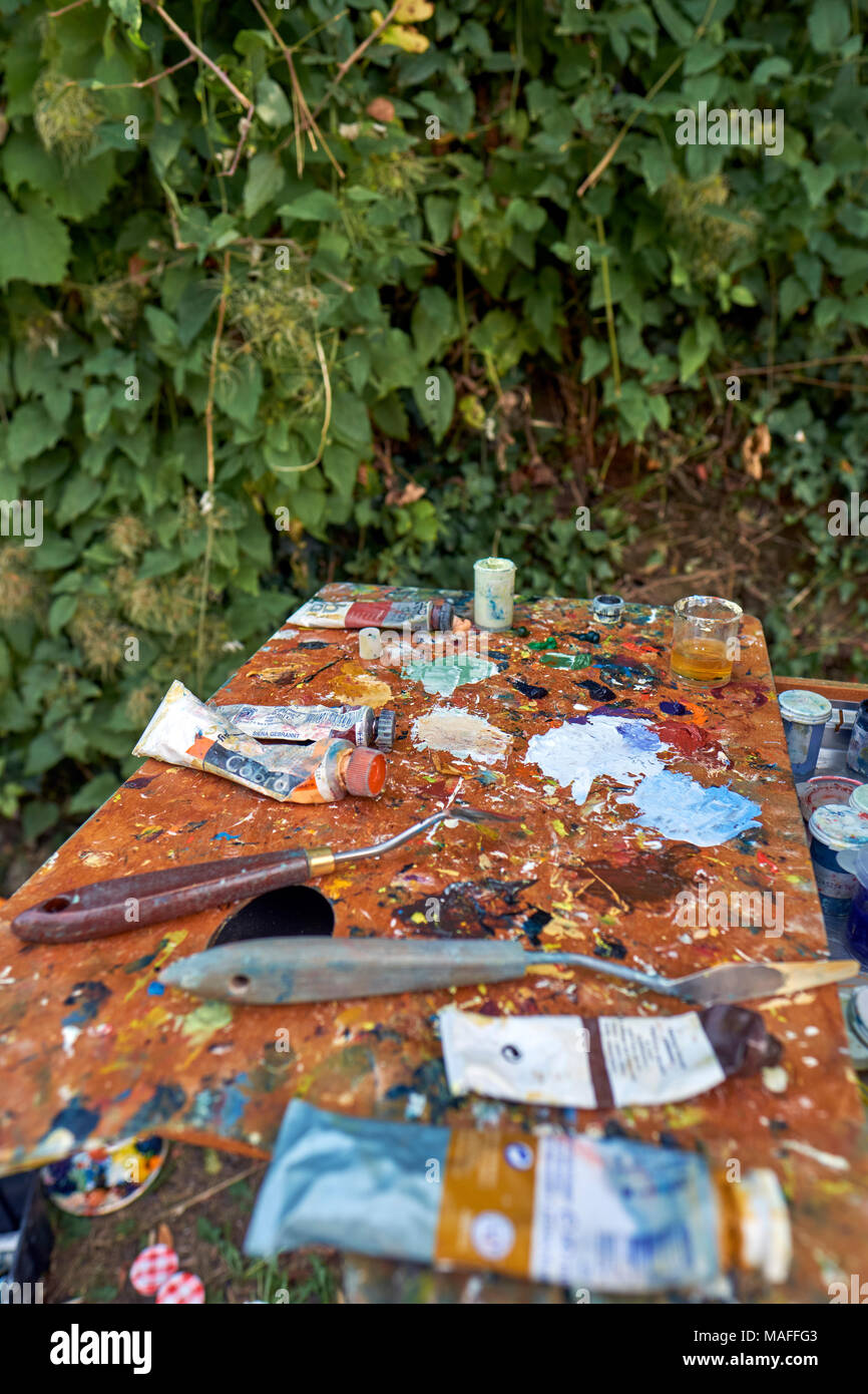 An artists oil paint palette in use out on location. Stock Photo