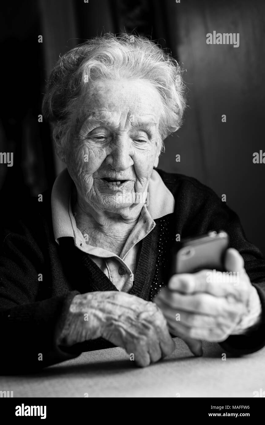 Elderly woman typing on the smartphone. Stock Photo