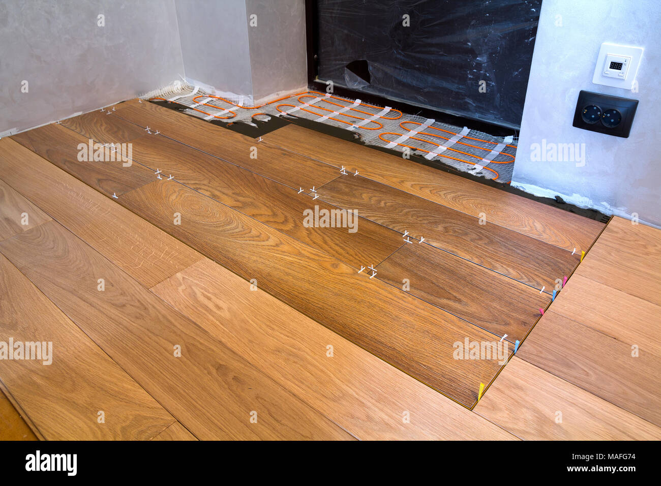 Installation of ceramic tiles and heating elements in warm tile floor