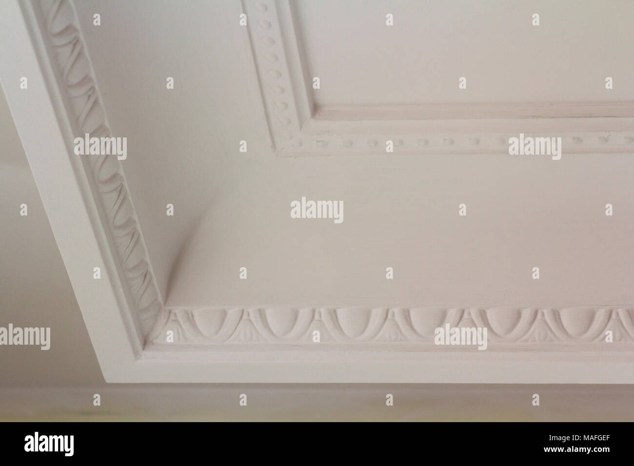 Ornamental White Molding Decor On Ceiling Of White Room