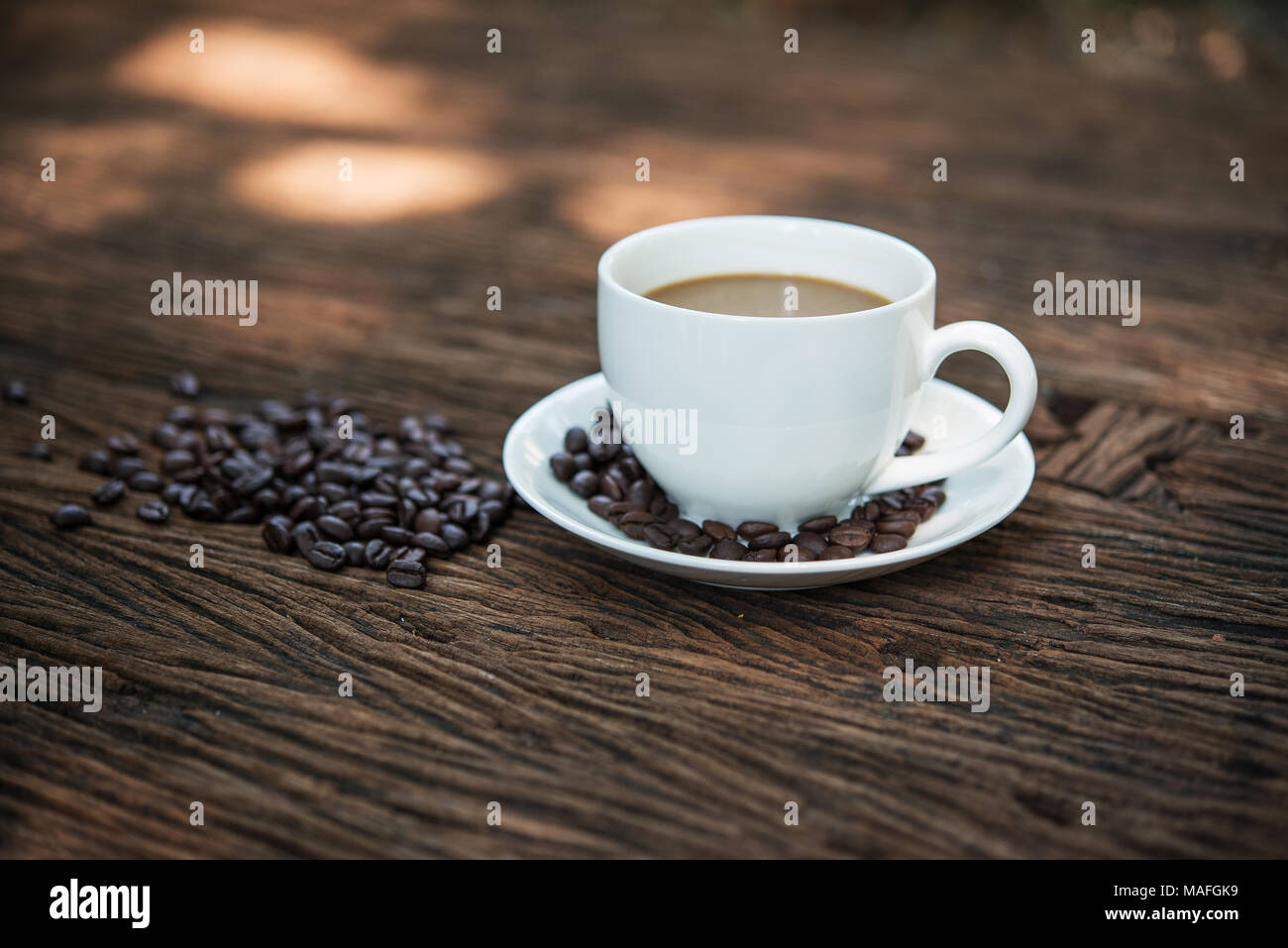 Coffee cup and coffee beans on wooden table Stock Photo - Alamy