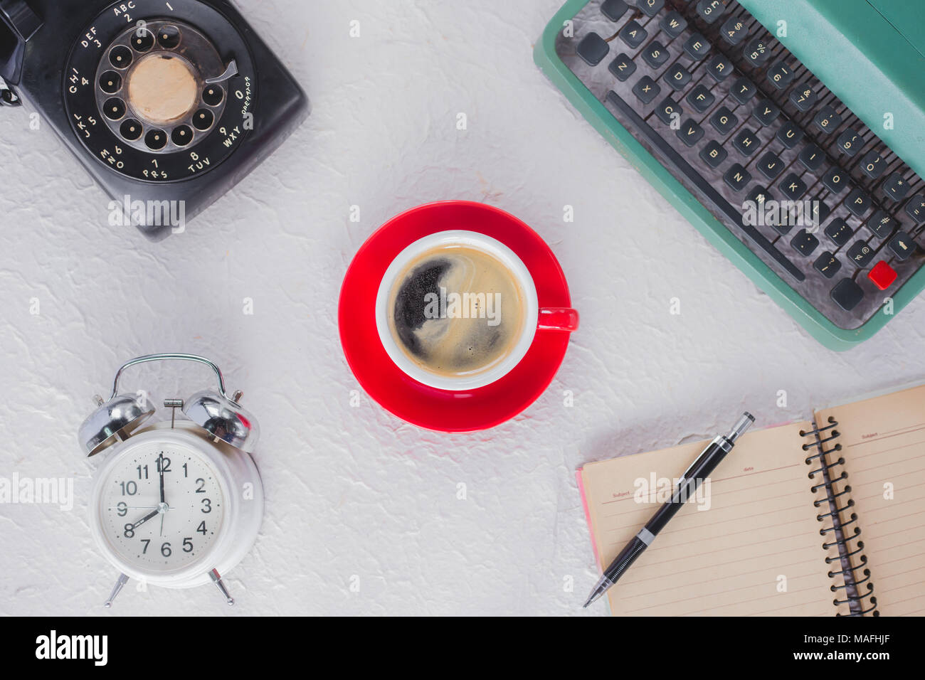 A cup of coffee with typewriter , alarm clock , telephone , notebook . top view image Stock Photo