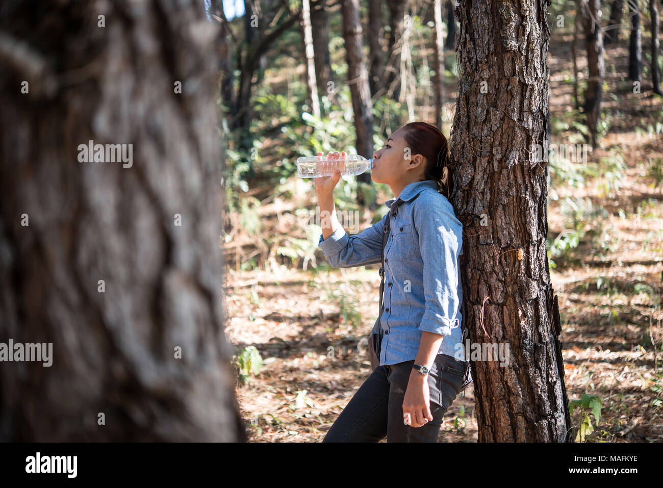Portrait of female backpacker drinks fresh water from the bottle while