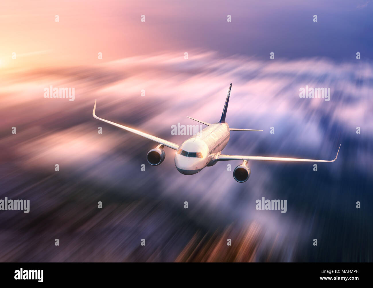 Big modern white airplane with motion blur effect is flying over low ...