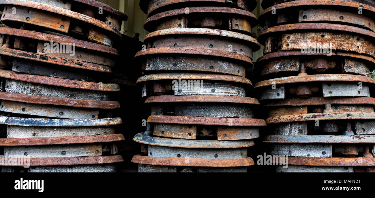 Vintage antique automotive brake shoes connected to backing plates in a pile at a wrecking yard. Stock Photo