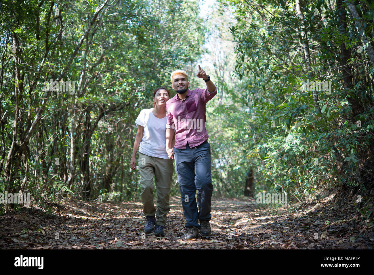 Young attractive couple hiking in the forest Stock Photo - Alamy