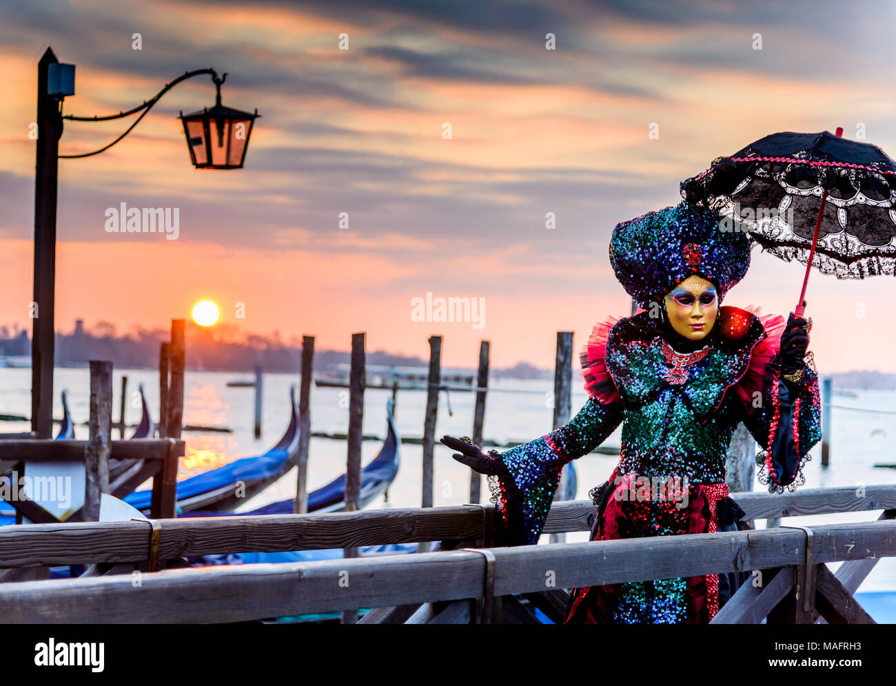 Venice, Italy - 11th February 2018: Carnival of Venice, beautiful mask at Mark's Square with St. George island in the background. Stock Photo