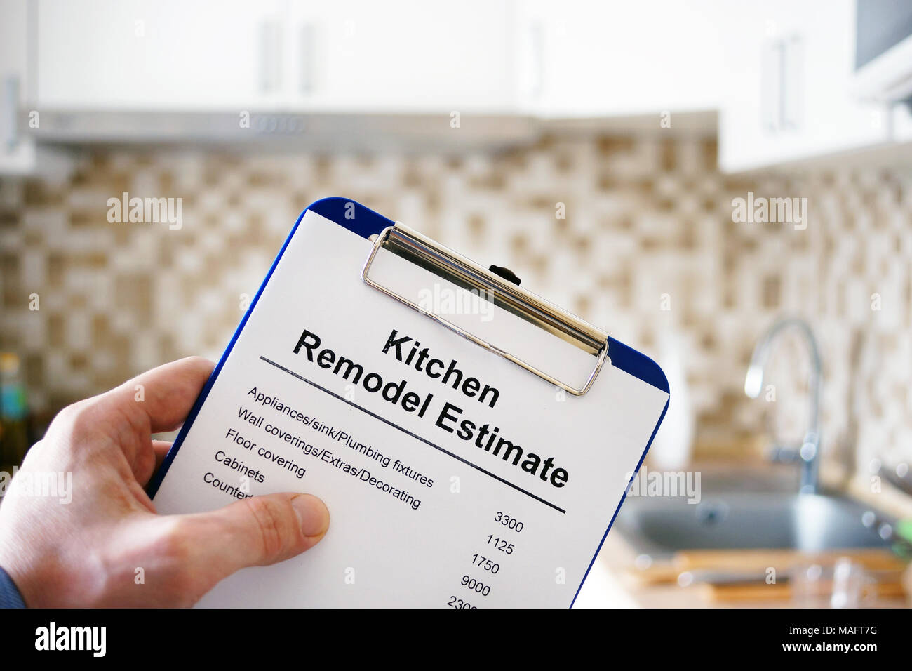 Clipboard with Kitchen remodel estimate. Cost of renovation. Stock Photo