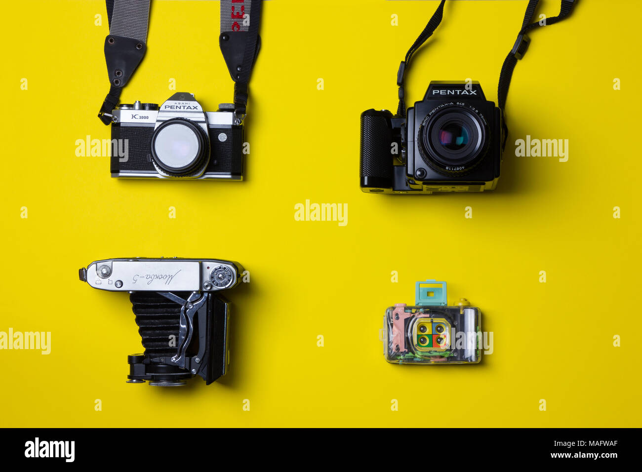a fantastic studio shot of film cameras taken from above against a bright yellow background Stock Photo