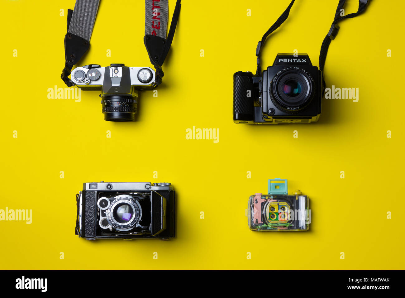 a fantastic studio shot of film cameras taken from above against a bright yellow background Stock Photo