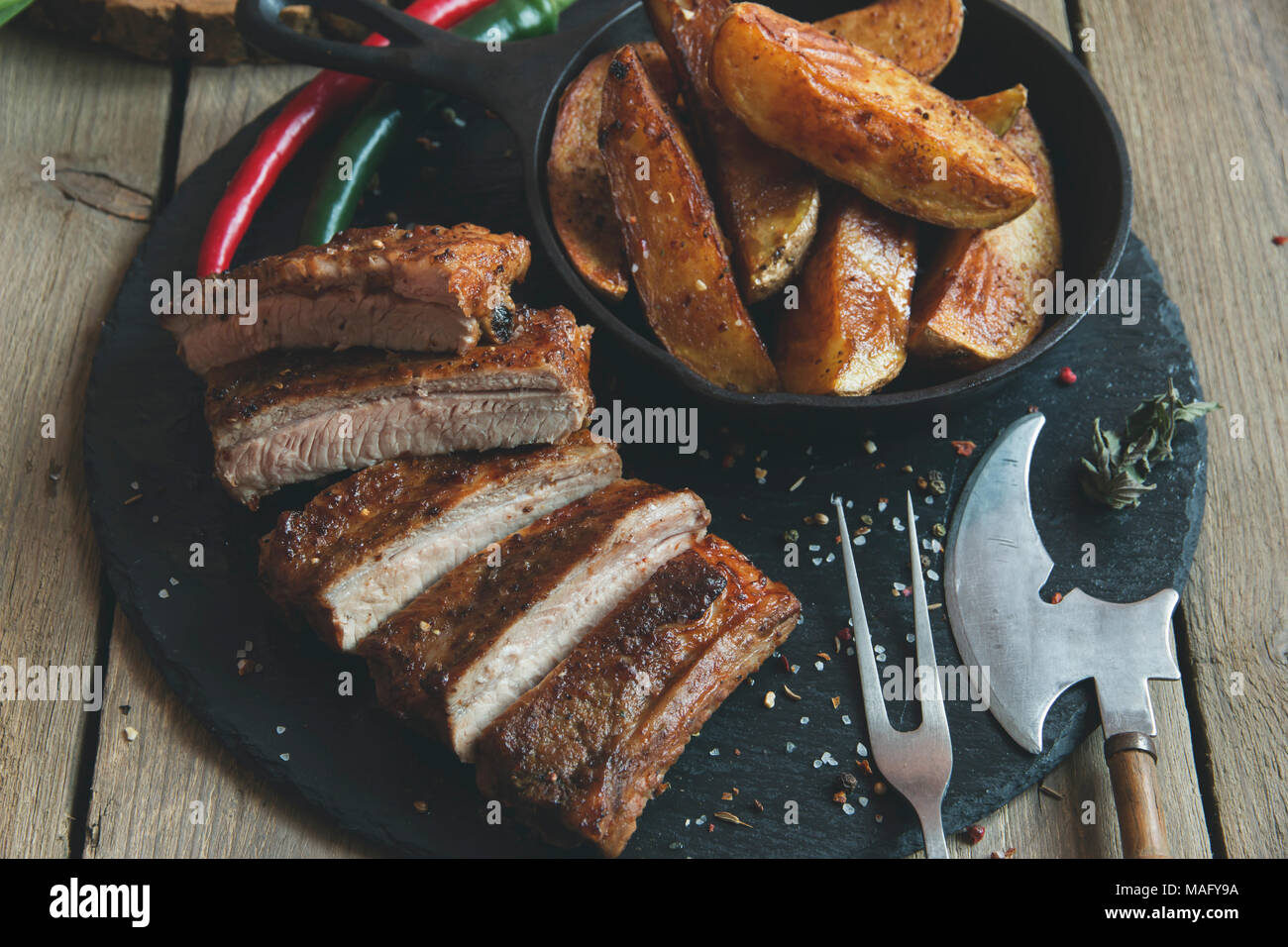 fried pork ribs with potatoes and spices Stock Photo