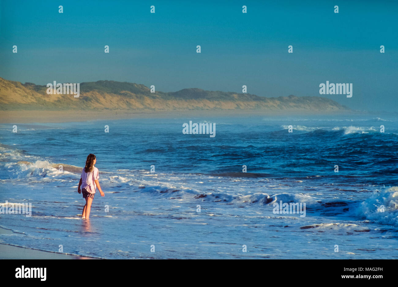 Woman standing on beach looking out to sea Stock Photo - Alamy