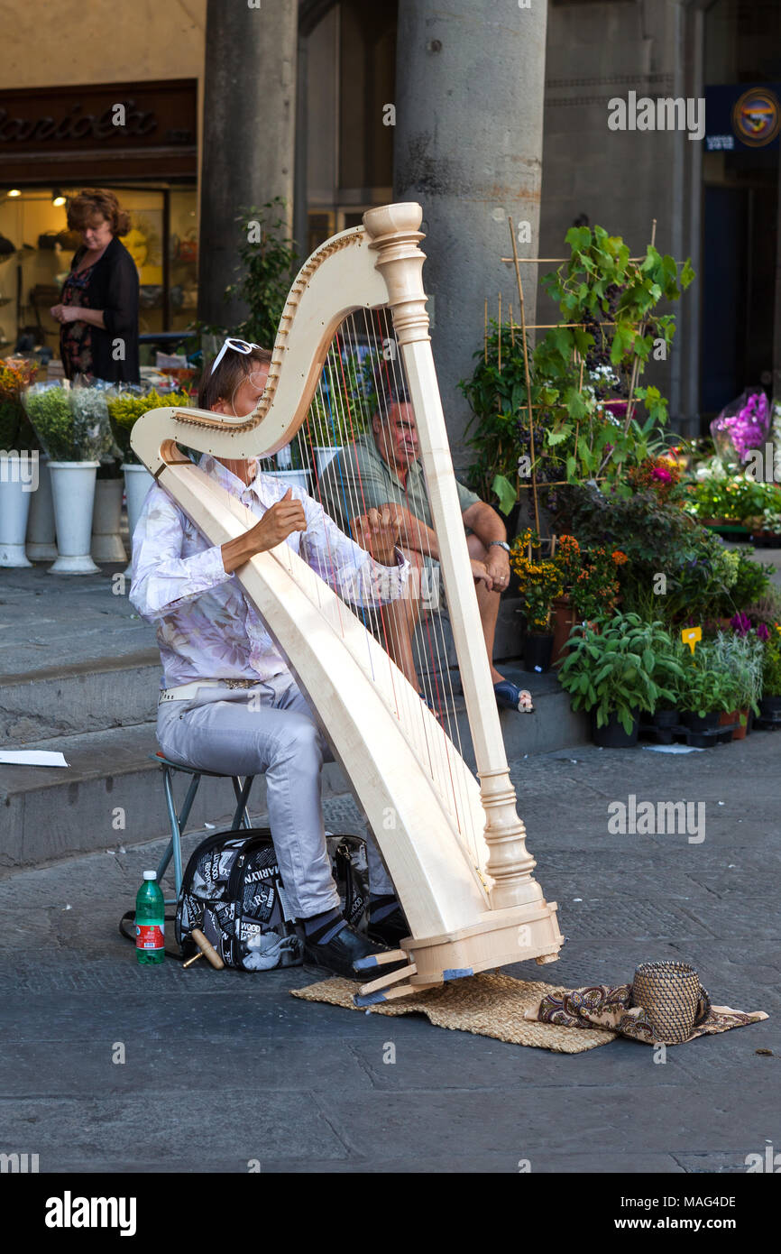 Busker. Harp player Lucca Italy Stock Photo