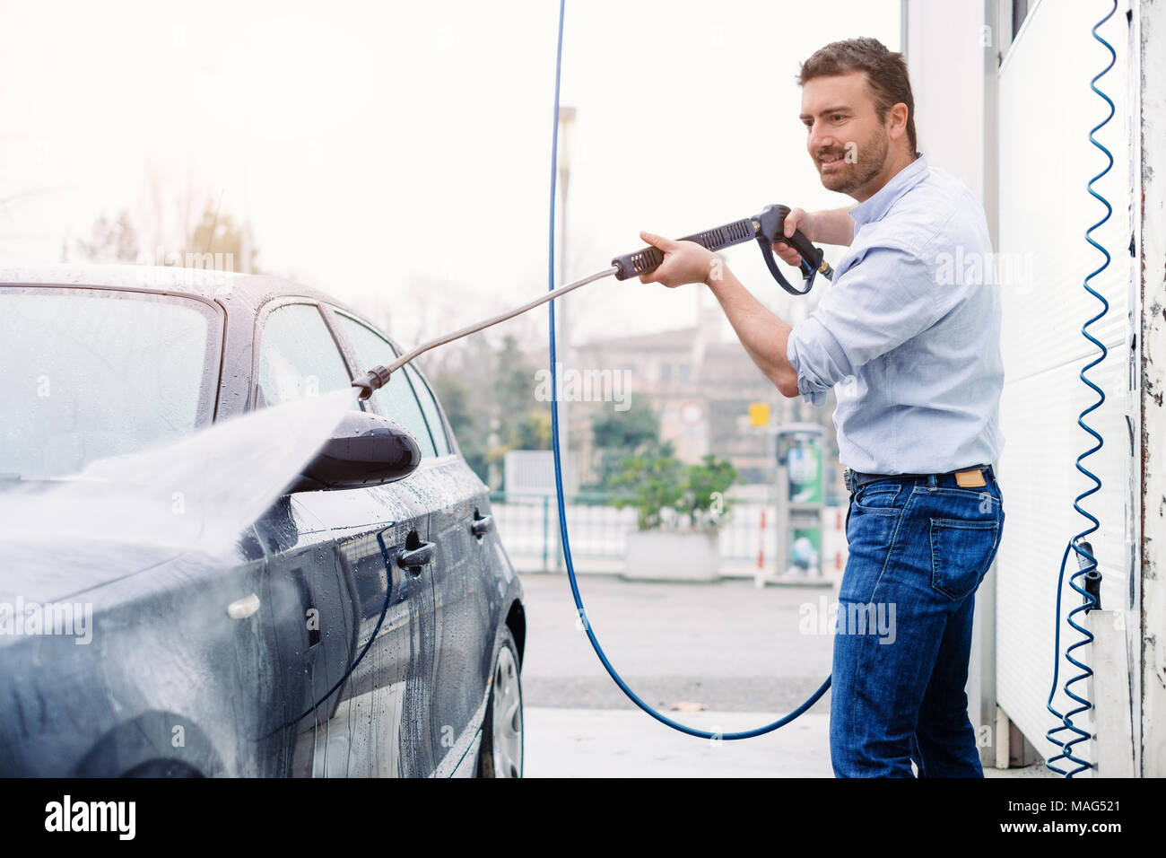 Man washing his car in a selfservice car wash station Stock Photo Alamy