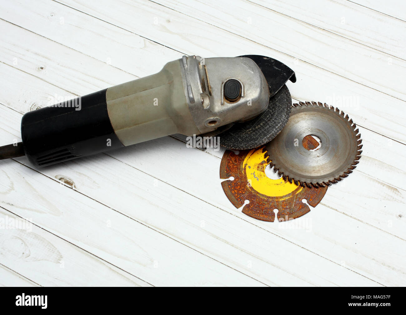 Hand saw circular saw and two metal discs isolated on white wooden surface. Stock Photo
