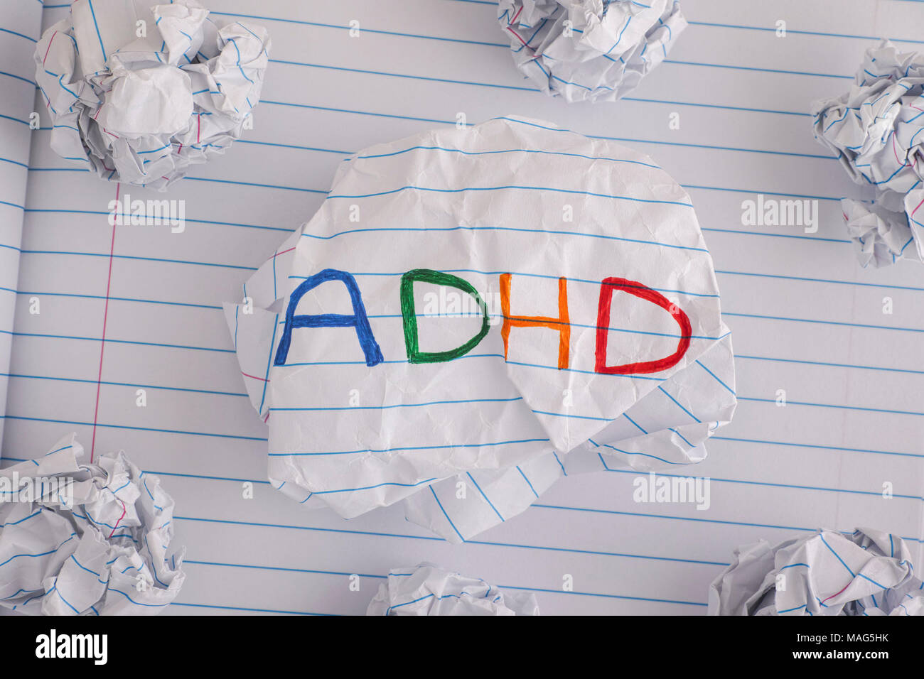 ADHD. Abbreviation ADHD on crumpled paper ball. Close up. ADHD is Attention deficit hyperactivity disorder. Stock Photo