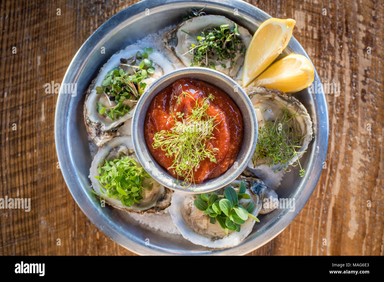 Freshly shucked oysters with microgreen garnish at a restaurant in