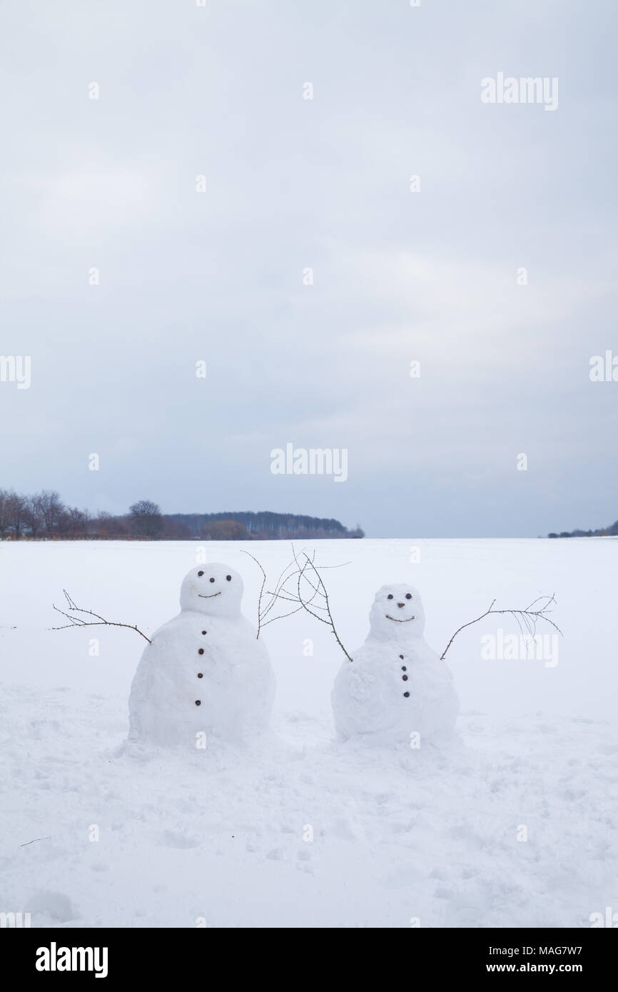 Two snowmen side by side in field in Dalgety Bay Fife Scotland Stock Photo